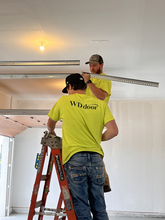 Garage Door Install WD Door expert installers hang track for a new garage door at a local home.