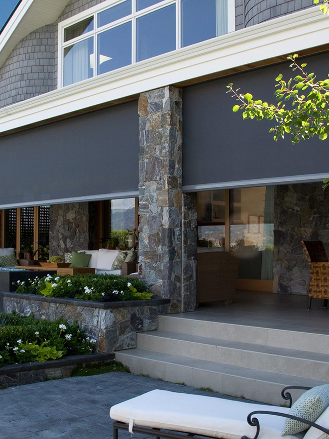 Retractable sun screens providing shade and privacy on a home’s front porch